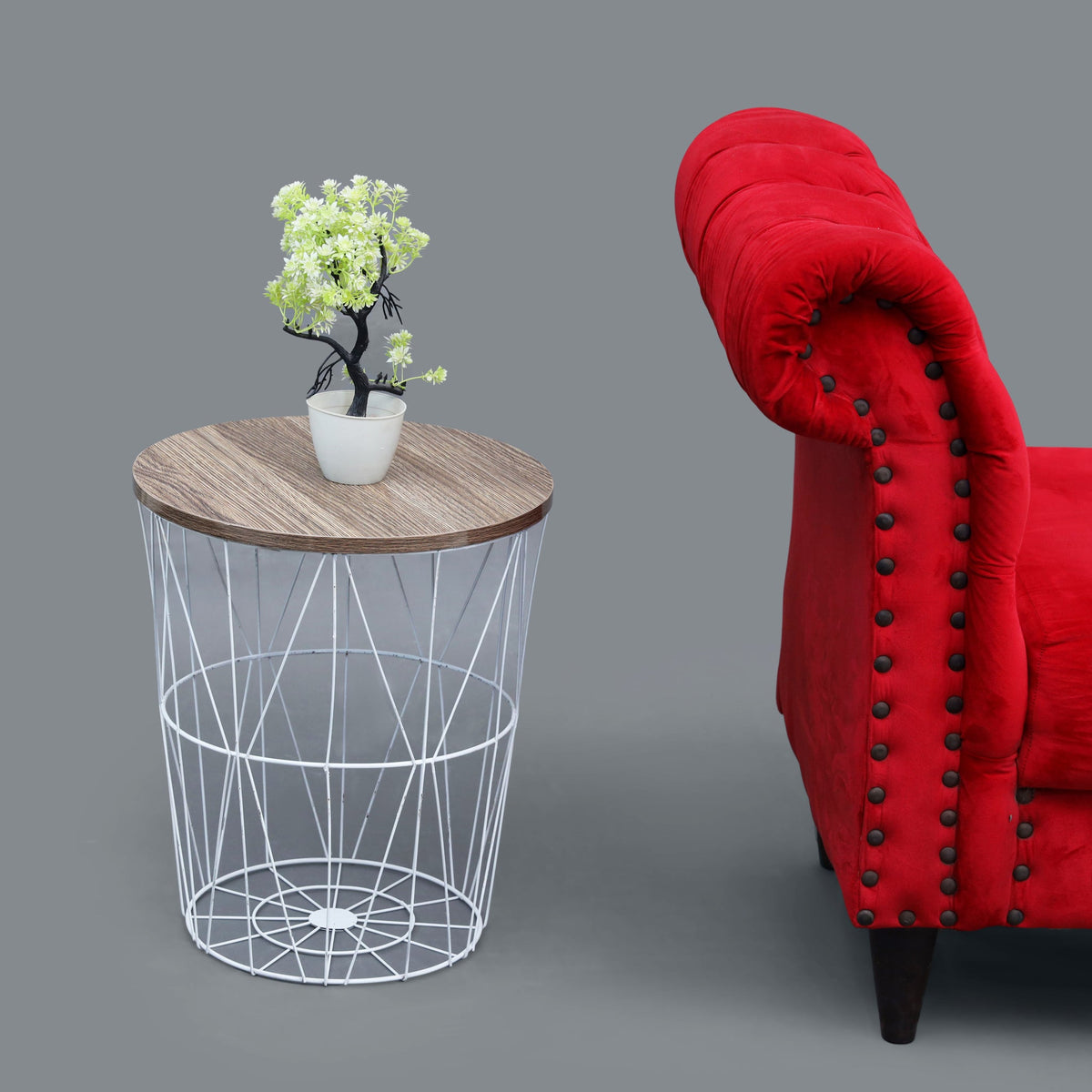White metal basket side table with wooden top next to sofa