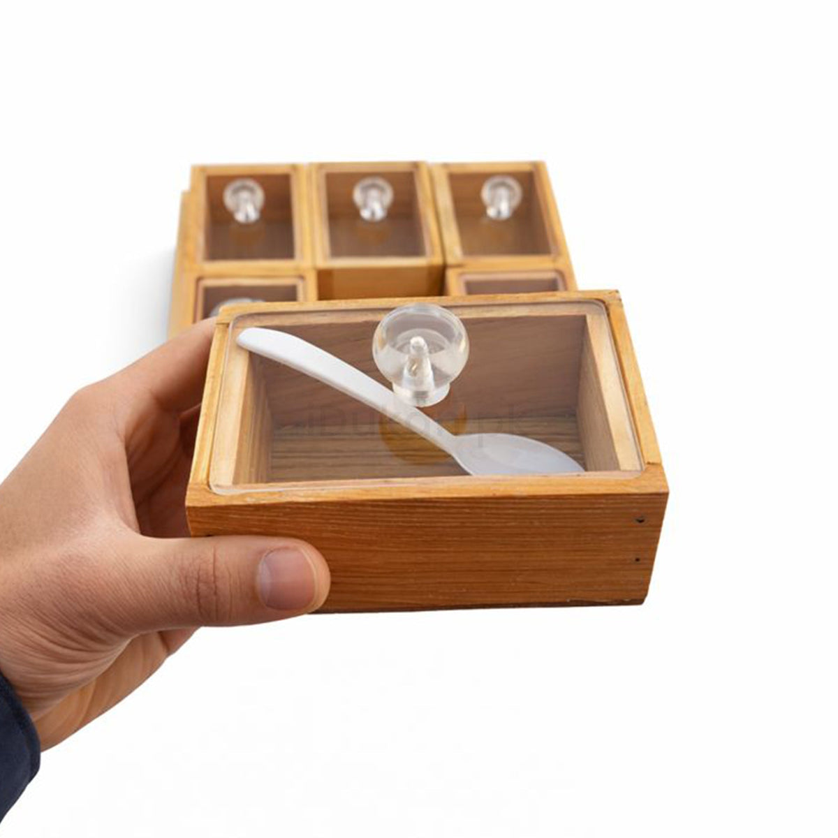 Hand holding wooden storage box with acrylic lid and spoon