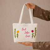 Hand holding Best Sister Ever embroidered canvas bag