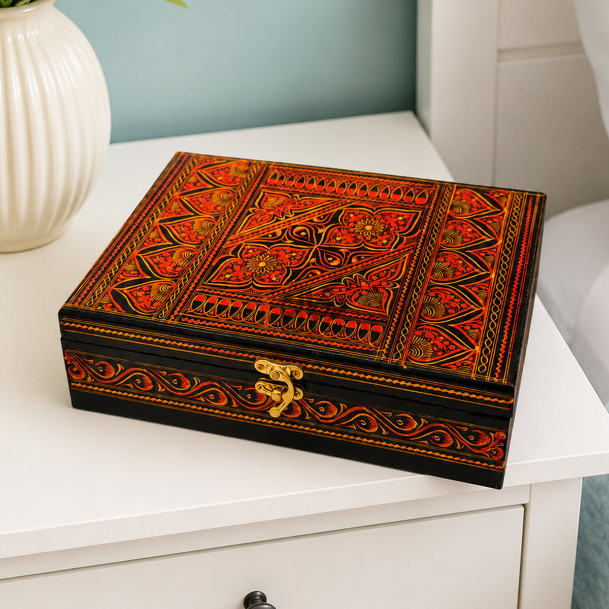 Large red wooden jewelry box on white side table