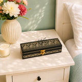 Small Golden black wooden jewelry box on white side table