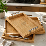 Nested wooden serving trays with steel handles on table