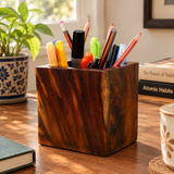 Wooden pen holder with pencils and markers on desk